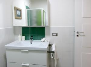 a white bathroom with a sink and a mirror at Flora in Atrani