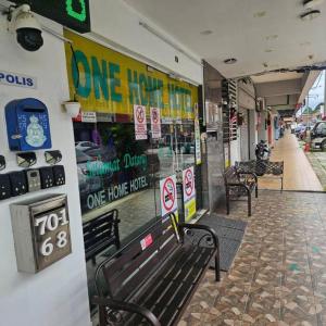 un banc dans un bâtiment avec des panneaux sur le mur dans l'établissement One Home Hotel, à Batang Kali
