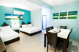 une chambre d'hôtel avec deux lits, une table et un bureau dans l'établissement Pice Hotel, à Kampong Permatang Batu 58 autres photos