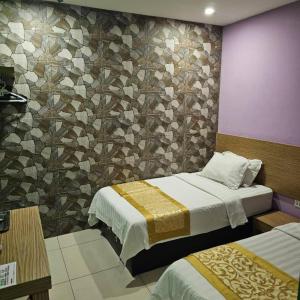 une chambre avec deux lits et un mur carrelé dans l'établissement One Home Hotel, à Batang Kali