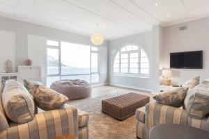 a living room with two couches and a tv at The Cove in Fish hoek