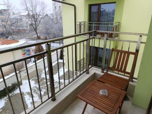 a wooden chair sitting on a balcony with snow on the ground at Lime House, Kyustendil in Kyustendil