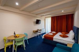 ein Hotelzimmer mit einem Bett und einem Tisch und Stühlen in der Unterkunft Four Seasons - New Gudauri in Gudauri + 227 Fotos