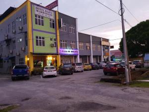 a parking lot with cars parked in front of a building at HOTEL BAJET MUGHOH SENGOTI in Kampong Gong Kempas +74 photos