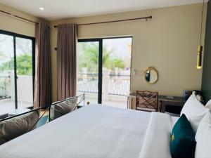 1 dormitorio con cama blanca y balcón en Vrest Hotel Otres Beach, en Sihanoukville 20 fotos más