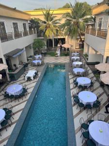 eine Draufsicht auf einen Pool mit Tischen und Stühlen in der Unterkunft Vrest Hotel Otres Beach in Sihanoukville