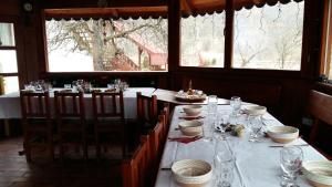 a dining room with a table with plates and glasses at Pensiunea Casa Butnarului in Geoagiu de Sus