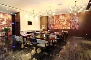 ein Restaurant mit Tischen und Stühlen in einem Raum in der Unterkunft Zmax Changzhi Bayi Square in Changzhi