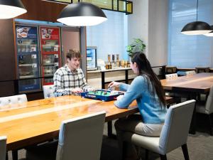 two people sitting at a table playing a board game at Tokyu Stay Suidobashi in Tokyo