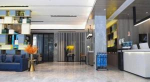 um átrio com um sofá azul num edifício em Echarm Hotel Xiangyang Erqi em Xiangfanbei