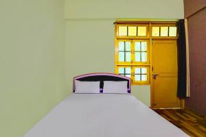 Una cama blanca en una habitación con ventana. en HOTEL O SK GRAND, en Sitāpur