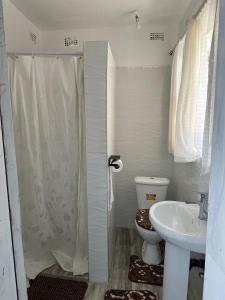 a bathroom with a shower and a toilet and a sink at Staylax guesthouse in Harare