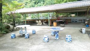 a patio with blue and white tables and chairs at Seasons Inn in Jiaoxi