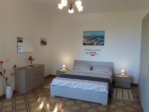 una camera da letto con un letto e un lampadario di La Casa del Sole a Vico Equense