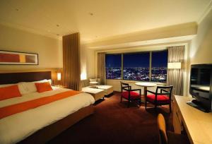 a hotel room with a bed and a table with a view at Yokohama Royal Park Hotel in Yokohama