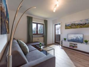un salon avec un canapé et une télévision dans l'établissement Zahmer Kaiser, à Oberaudorf