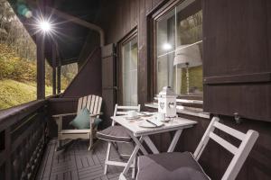 eine Veranda mit einem Tisch und Stühlen auf einem Haus in der Unterkunft Bergschlössl - Massionettwohnung 13 in Oberaudorf