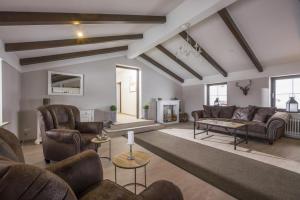 ein großes Wohnzimmer mit Sofas und einem Tisch in der Unterkunft Bergschlössl - Massionettwohnung 13 in Oberaudorf