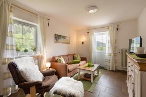 ein Wohnzimmer mit Sofa und Tisch in der Unterkunft Bergschlössl Whg 10 in Oberaudorf