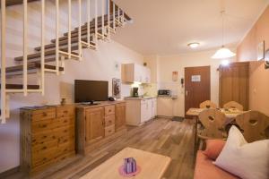 ein großes Wohnzimmer mit einer Küche und einer Treppe in der Unterkunft Bergschlössl - Maissonettwohnung 15 in Oberaudorf