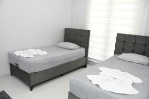 Habitación con 2 camas individuales y paredes blancas. en KAYACİTY Rezidans, en Nevşehir