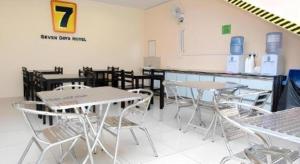 un groupe de tables et de chaises dans une pièce dans l'établissement Super OYO 635 Seven Days Hotel, à Kampong Sempalit Hilir