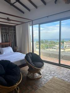 une chambre avec un lit et une grande fenêtre dans l'établissement Iddamal Bay Apartments, à Dehiwala-Mont Lavinia