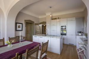 eine Küche und ein Esszimmer mit weißen Schränken und einem Tisch in der Unterkunft Villa Stigloh in Oberaudorf