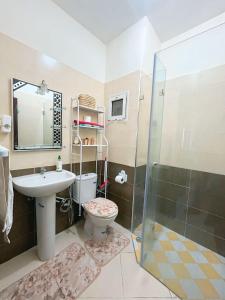 a bathroom with a sink and a toilet and a shower at Nice apartment by the beach in Sale