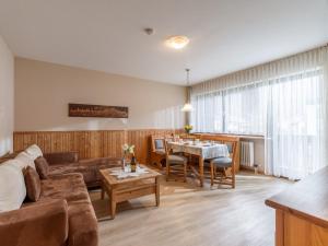 un salon avec un canapé et une table dans l'établissement FerienwohnanlageOberaudorf B5 mit Hallenbad und Sauna, à Oberaudorf