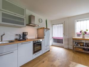 a kitchen with white appliances and wooden floors at Moderne Bergstube mit 2 Schlafzimmer und großen Balkon in Oberaudorf