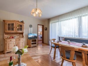 a living room with a dining room table and a television at Ferienwohnanlage Oberaudorf D 2 mit Hallenbad und Sauna in Oberaudorf