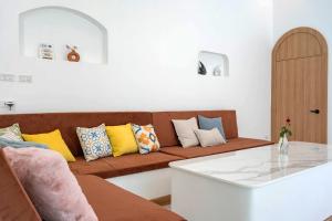 a living room with a brown couch with colorful pillows at Downtown Oasis 芭提雅市中心独栋泳池别墅 A 5卧6卫 KTV BBQ 芭提雅海滩步行街500m in Pattaya South +140 photos