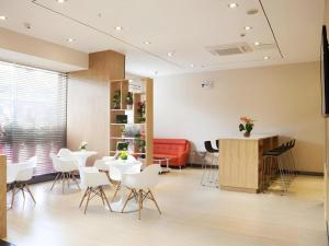 a waiting room with white chairs and a red couch at 7 Days Inn Zhangjiakou Chongli Yuxing Road in Chongli
