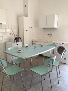 cocina con mesa, sillas y lavadora en Affittacamere del viaggiatore en Ancona