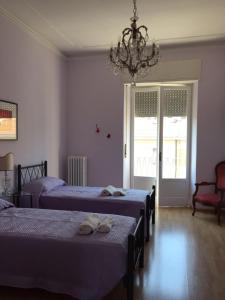 安科納的住宿－Affittacamere del viaggiatore，一间卧室配有两张床和吊灯。
