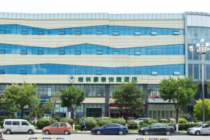 a large building with cars parked in front of it at GreenTree Inn Linxi International Convention Center Express Hotel in Wangjiaqiao