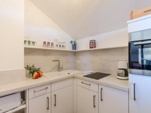 eine Küche mit weißen Schränken und einer Spüle in der Unterkunft Ferienwohnanlage-Oberaudorf 1 Zimmer App E 8 mit Hallenbad und Sauna in Oberaudorf