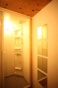 a bathroom with an open door to a refrigerator at Base Inn Komagome Tokyo in Tokyo