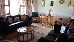 ein Wohnzimmer mit Sofa und Tisch in der Unterkunft Brenton Lake Holiday Cottages in Brenton-on-Sea