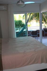a bedroom with a bed with a view of a hammock at Camboinhas Oceanside Oceanfront in Rio de Janeiro