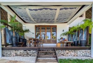 a woman sitting on the porch of a house at Boutique Hotel Matlai in Michamvi