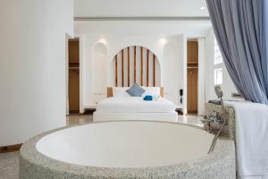 a bathroom with a bath tub and a bed at Downtown Oasis 芭提雅市中心独栋泳池别墅 A 5卧6卫 KTV BBQ 芭提雅海滩步行街500m in Pattaya South