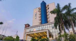 un immeuble d'hôtel avec une tour bleue au sommet dans l'établissement Jinjiang Inn Select Foshan Nanhai Guicheng Metro Station, à Nanhai