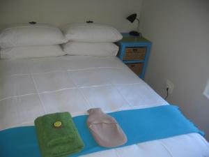 a bed with a green towel and pillows on it at The Loft House in Langebaan