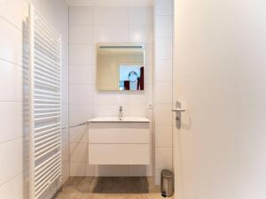 une salle de bain avec un lavabo et un miroir dans l'établissement Serene Holiday Home in De Koog Texel with Sauna, à Westermient