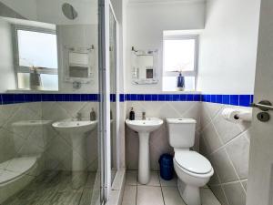 Un baño con inodoro, lavabo y ducha. en Modern Coastal Apartment in J-Bay, en Jeffreys Bay 19 fotos más