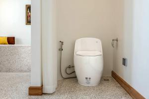 a bathroom with a toilet in the corner of a room at Downtown Oasis 芭提雅市中心独栋泳池别墅 A 5卧6卫 KTV BBQ 芭提雅海滩步行街500m in Pattaya South