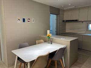 a kitchen with a white table and chairs at 인덕원스테이 27 in Mabun-ni