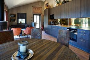 eine Küche mit einem Holztisch und blauen Schränken in der Unterkunft Daftö Resort in Strömstad